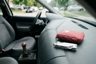 Brise-vitre et coupe-ceinture posés sur le tableau de bord d'une voiture, outils de sécurité automobile essentiels