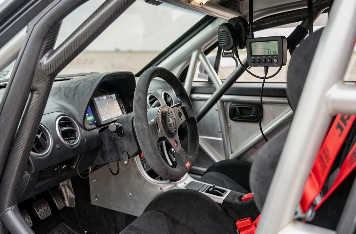 Intérieur d'un cockpit de voiture de rallye avec cage, tableau de bord et volant homologués