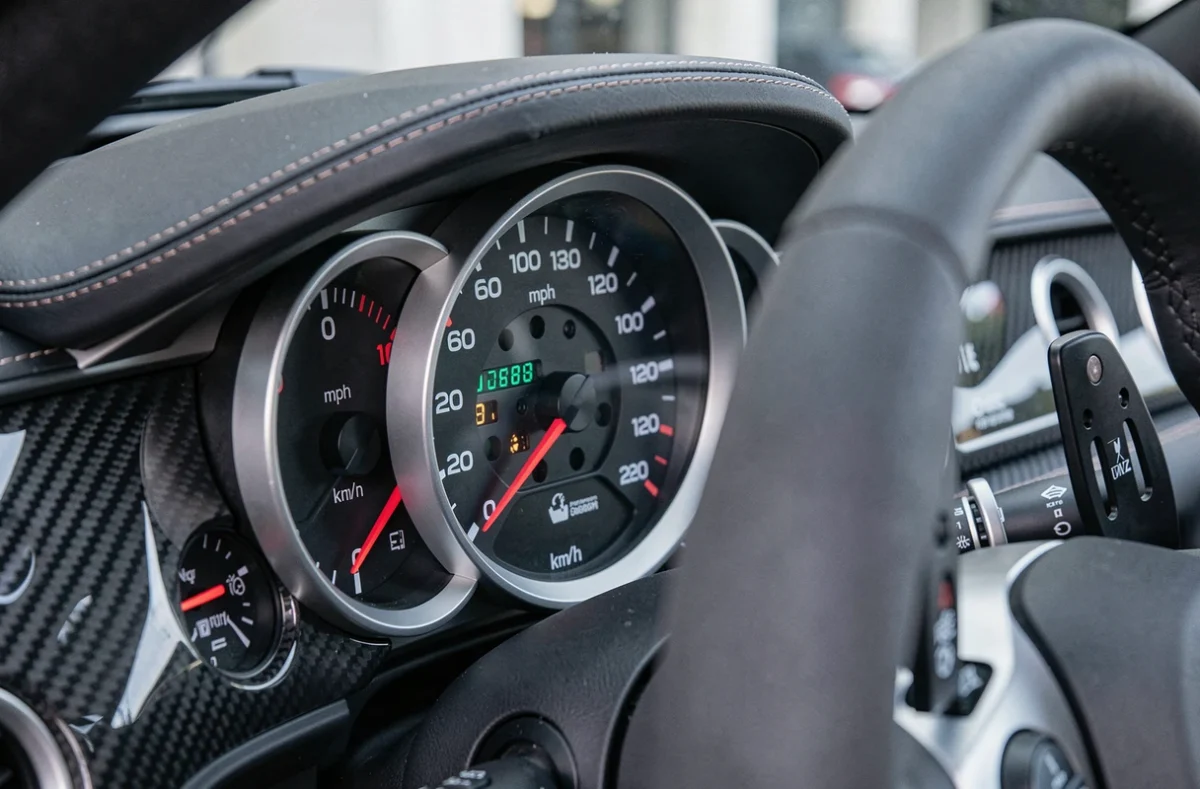 Tableau de bord de voiture de sport avec compteur de vitesse analogique indiquant 200 mph et les équivalents en km/h