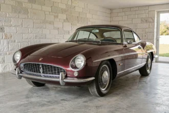 Facel Vega HK500 entièrement restaurée dans un garage privé, peinture bordeaux métallisée et chromes étincelants, vue grand angle trois quarts avant
