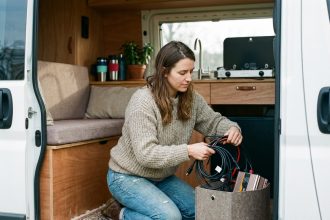 Femme en van organisant des câbles électriques dans un intérieur cosy