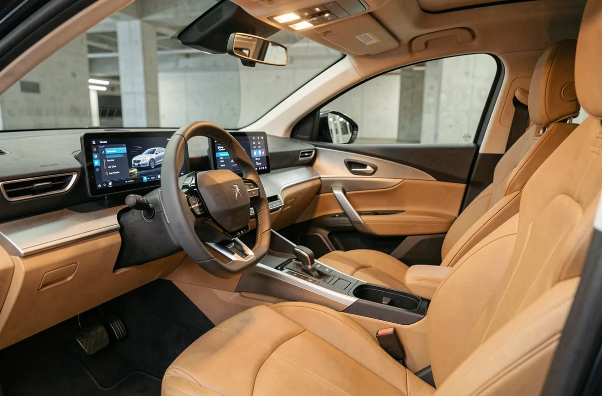 Intérieur du Peugeot 5008 avec tableau de bord i-Cockpit et sièges cuir beige, vue cockpit pour comparatif motorisations