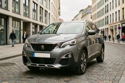 Peugeot 5008 gris métallisé garé en ville, vue 3/4 avant sur pavés parisiens pour guide d'achat moteur essence diesel hybride